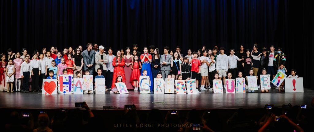 Performers and volunteers gather on stage after the 2023 Have A Great Summer charity performance.